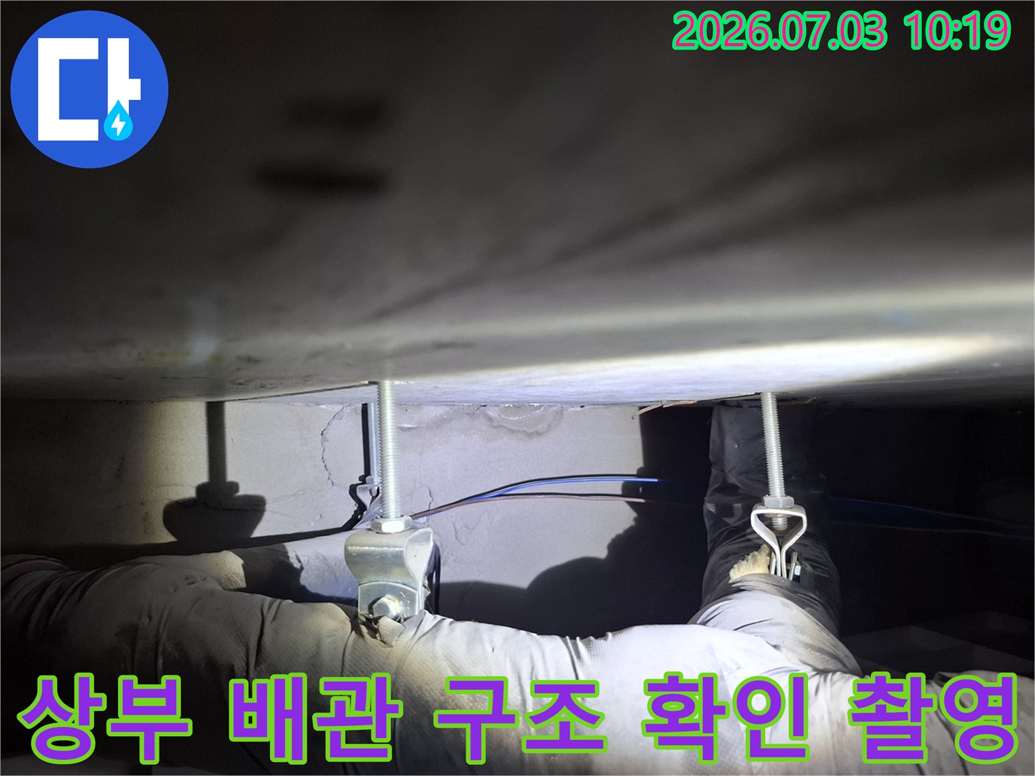 천장 내부의 복잡한 배관 연결망과 분기 지점을 점검하는 모습