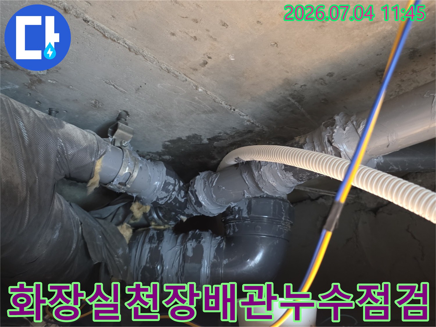 화장실 천장 점검구 내부의 배관 연결 부위와 노후된 매립 구간을 촬영한 모습