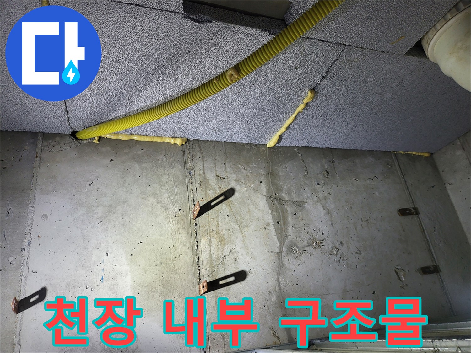 아파트 천장 내부-노란색 배관과 콘크리트 벽면