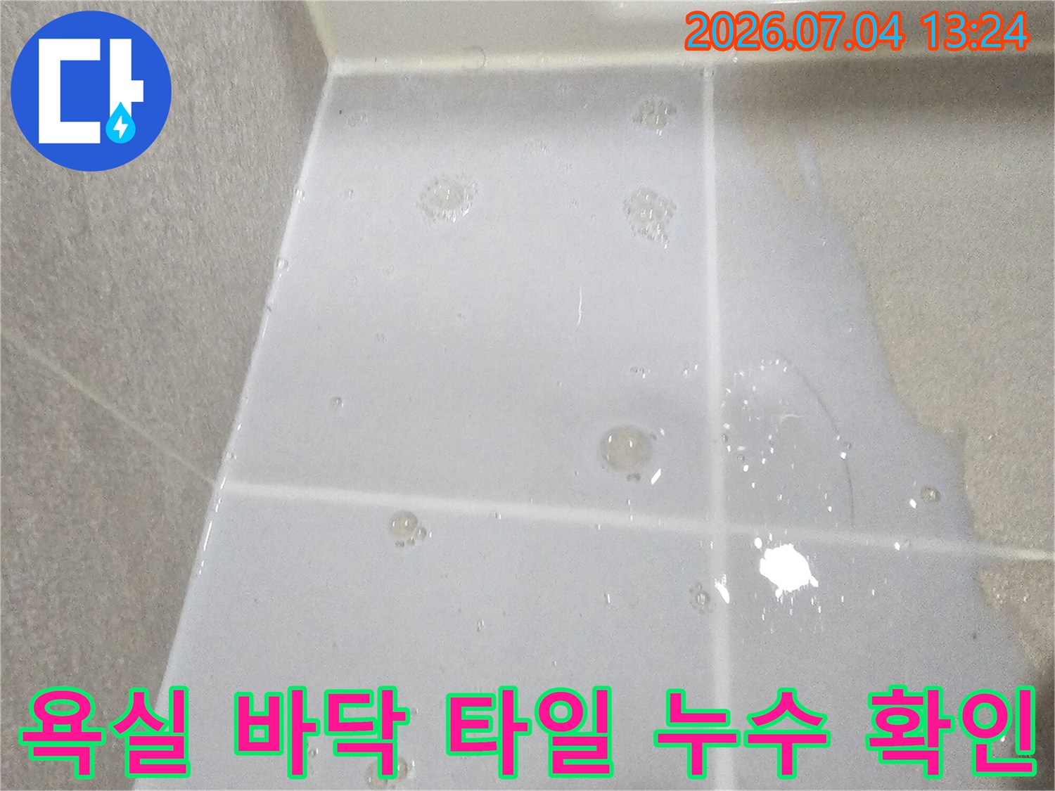 배관 수리 전 화장실 바닥의 물 고임과 습기 상태를 촬영한 모습