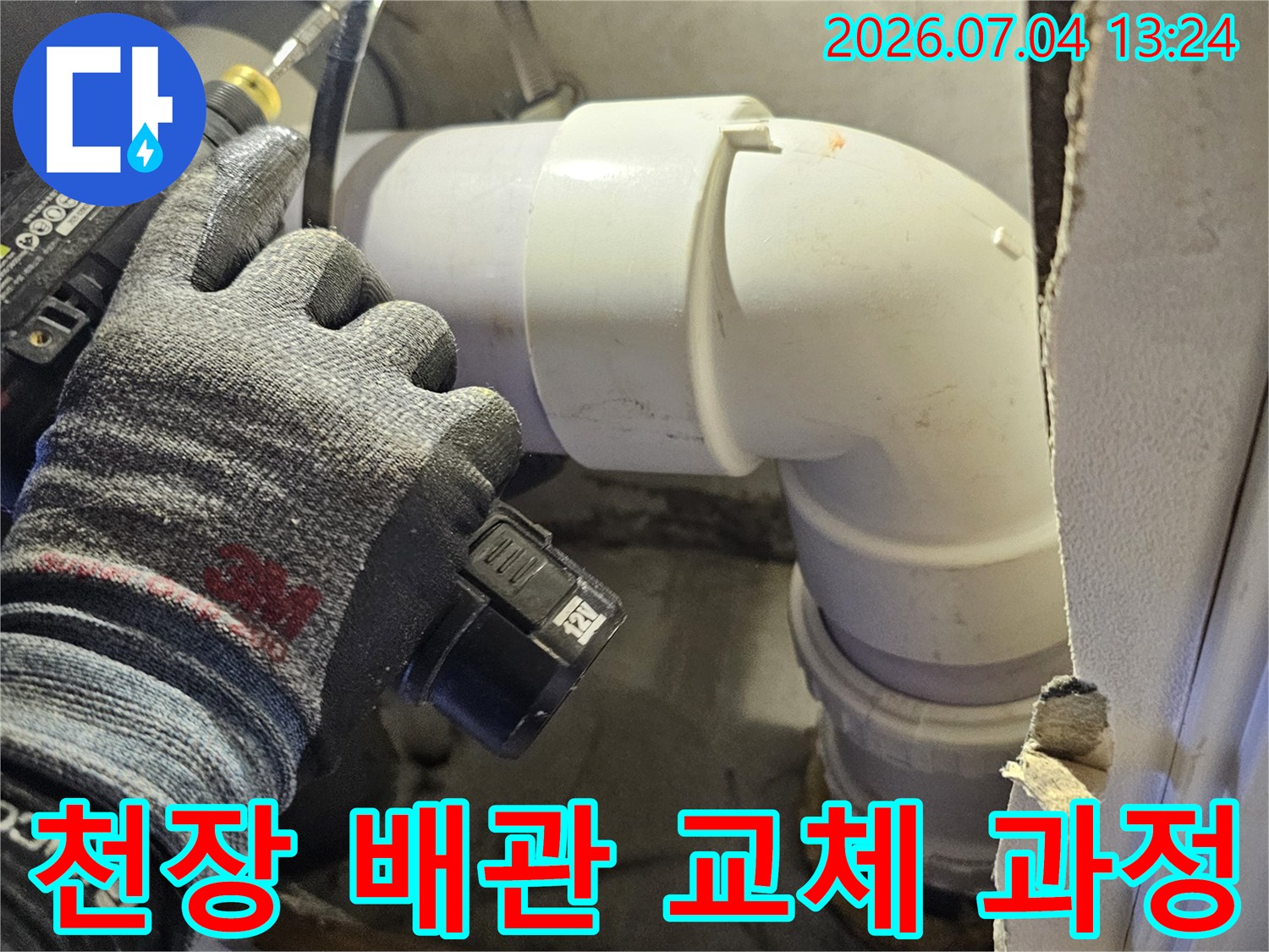 손등에 장갑을 착용하고 천장 내부 배관 연결 상태를 점검하는 모습