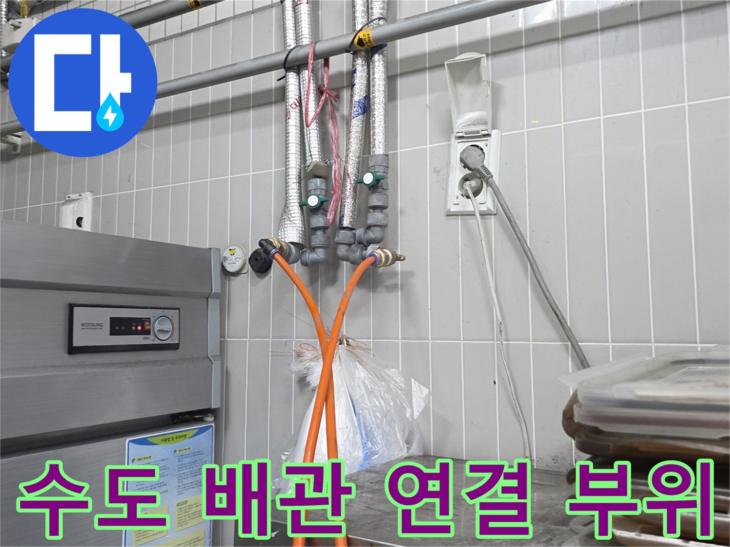 금속 재질의 배관과 주황색 점검용 호스가 연결된 모습