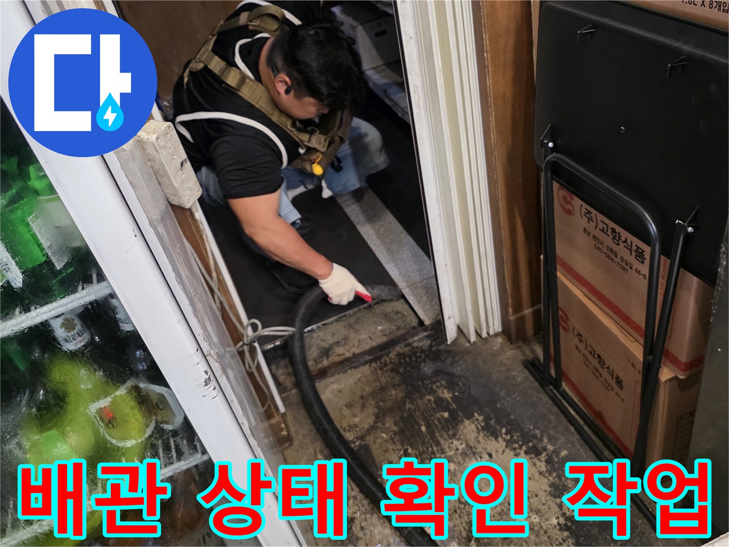 작업자가 좁은 공간에서 배관의 누수 여부를 면밀히 관찰하고 있습니다.