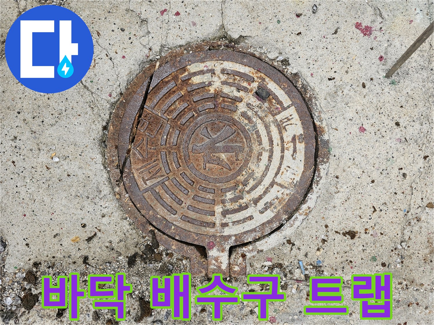 습기가 머물러 있는 현관 바닥의 철제 배수 덮개 상세 사진