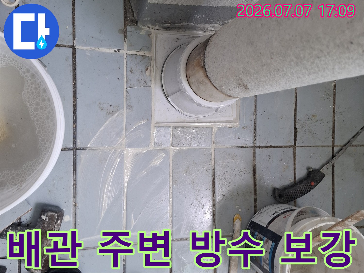 흰색 도료가 칠해진 우수관과 작업 중인 공구들이 보이는 누수 현장