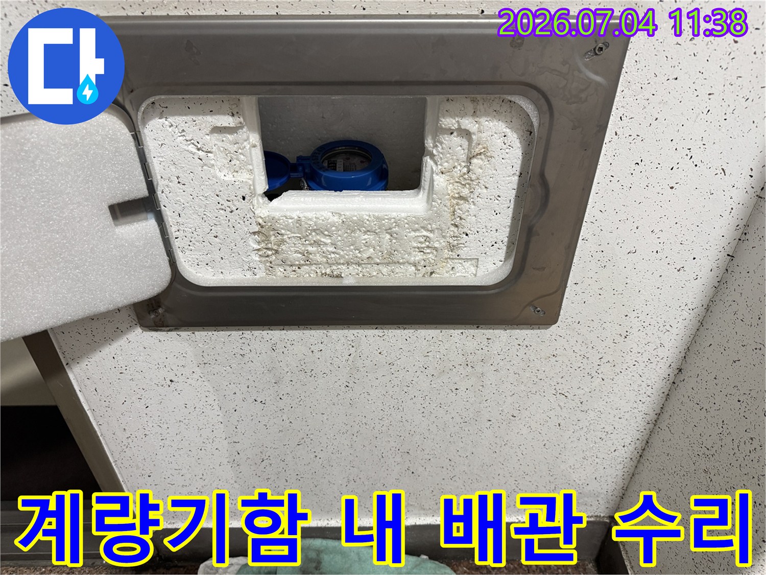 열린 계량기 함 속 파란색 장치와 흰색 단열재의 모습