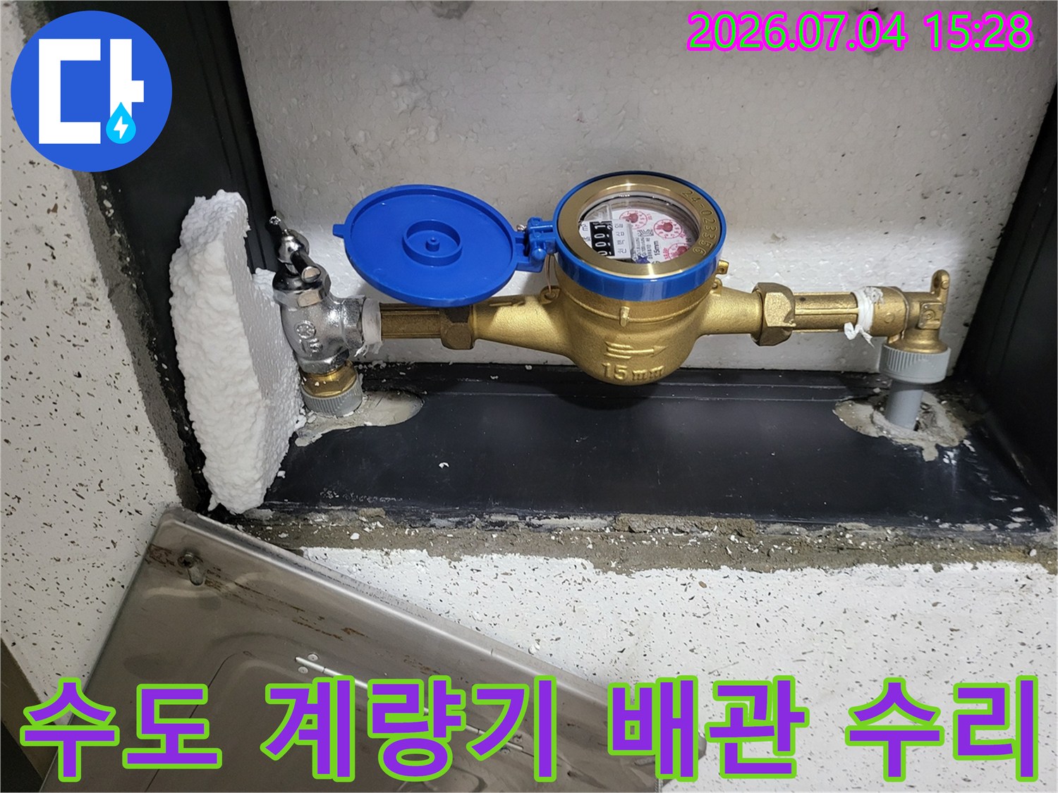 황동 밸브와 파란색 계량기가 포함된 수도계량기함 내부