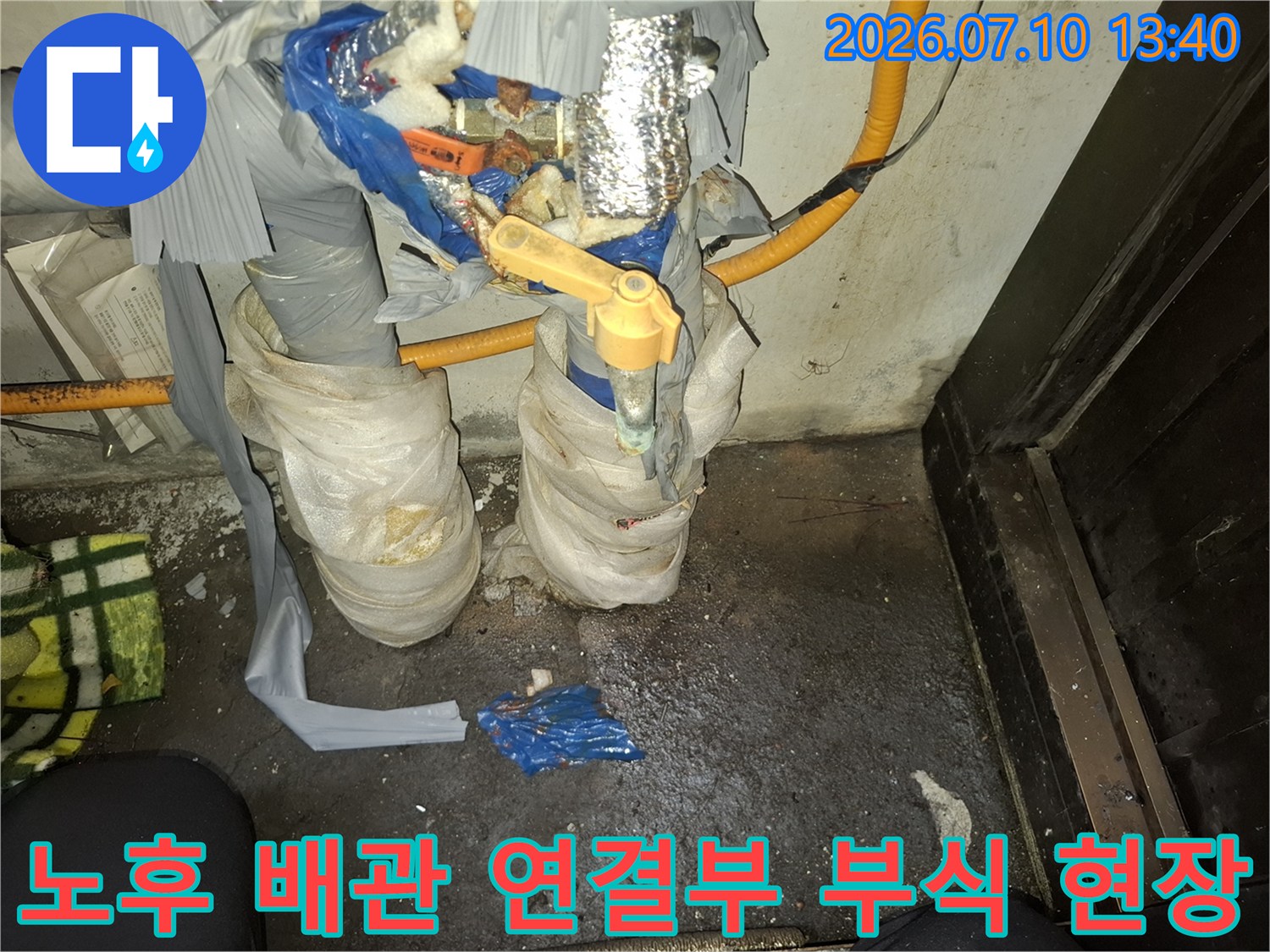 부식된 금속 배관과 젖은 보온재가 있는 누수 수리 현장