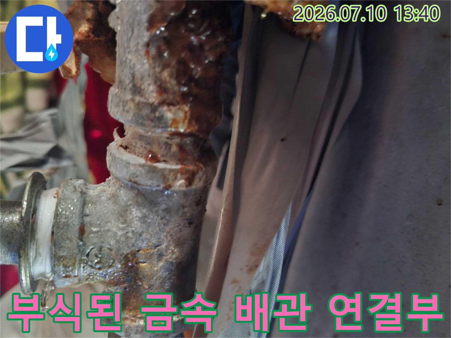 심하게 부식되어 녹이 슨 금속 배관의 연결 부위를 촬영한 사진