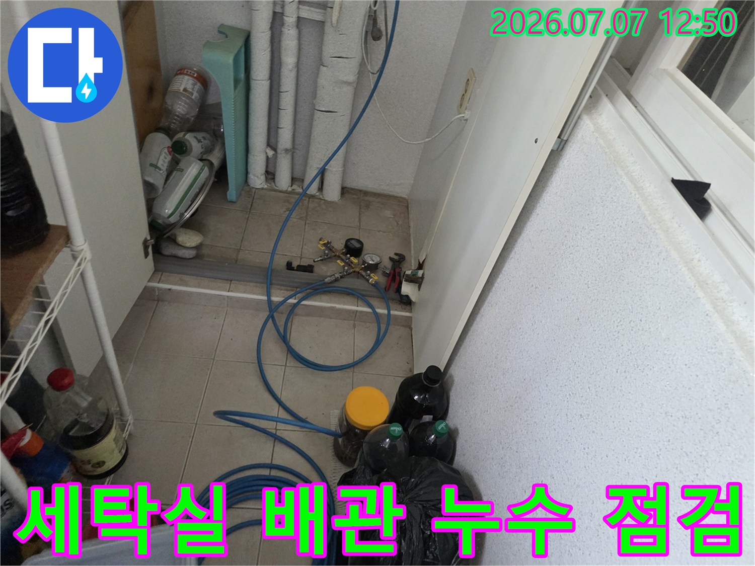 세탁실 내부 수도 밸브와 연결된 배관 및 호스 상태를 점검하는 모습