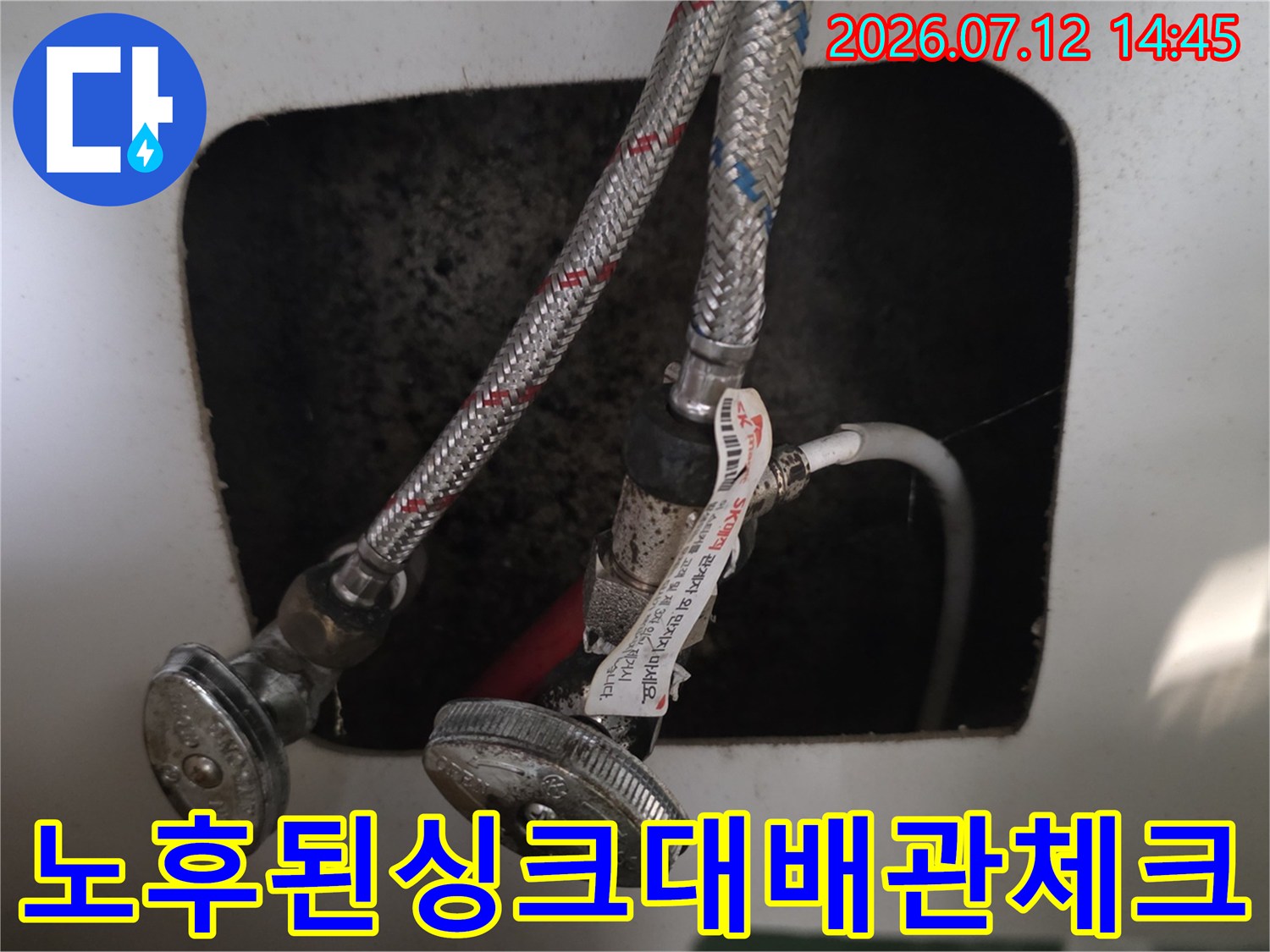 금속 재질의 싱크대 하부 배관 체결 부위 정밀 점검 모습