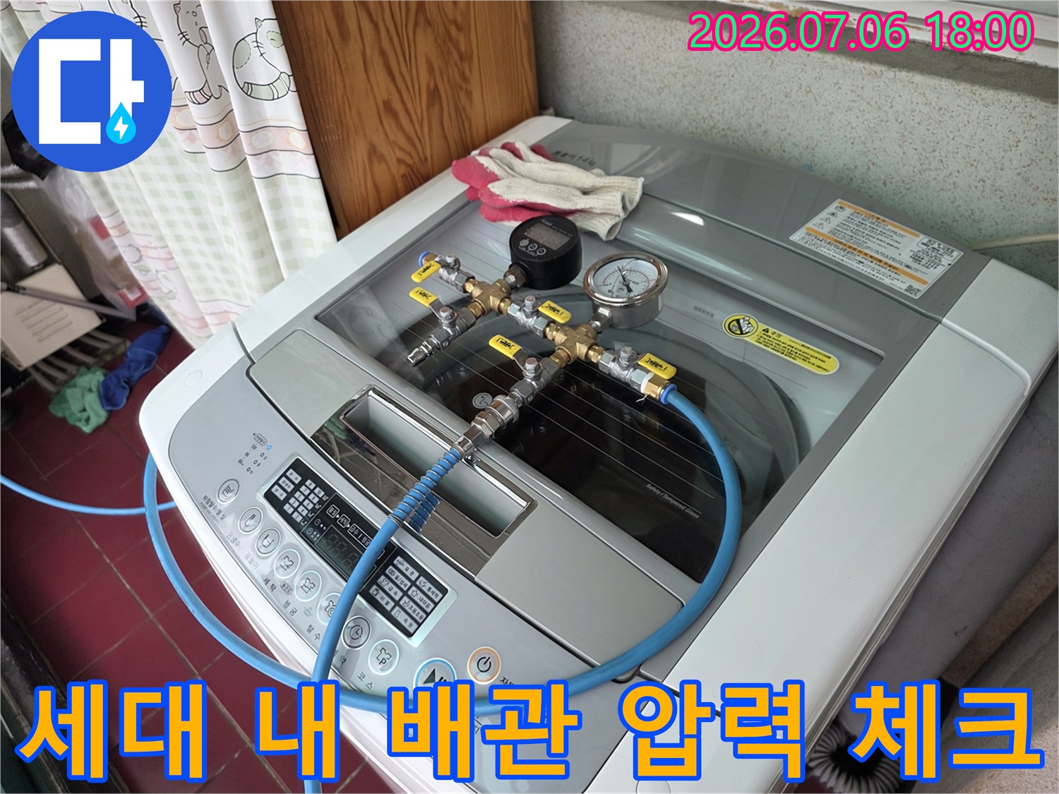 세탁실 배관에 연결된 전문 장비로 공압을 측정하며 누수 구간을 파악하는 모습
