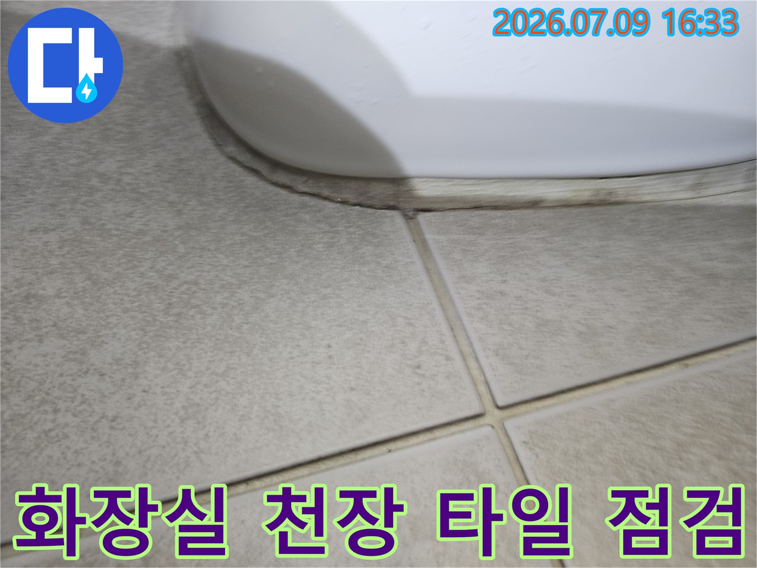 먼지가 묻은 화장실 천장의 타일과 배수구 주변 마감 부위