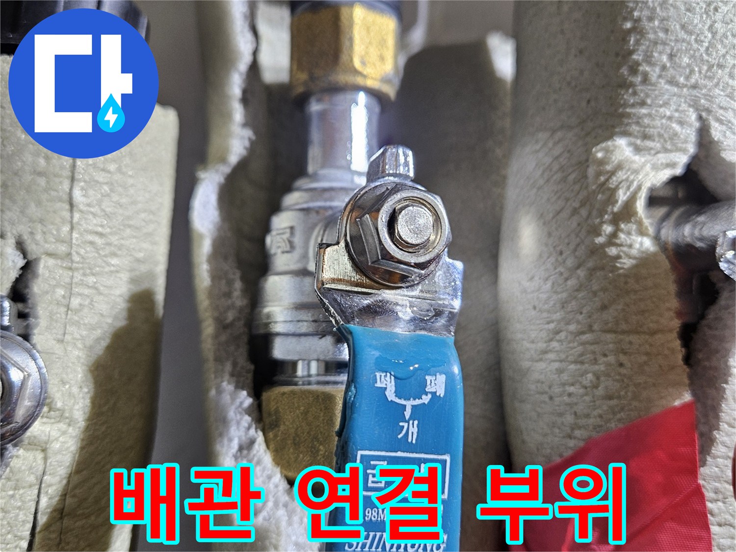 보온재가 씌워진 분배기 배관과 파란색 밸브 손잡이