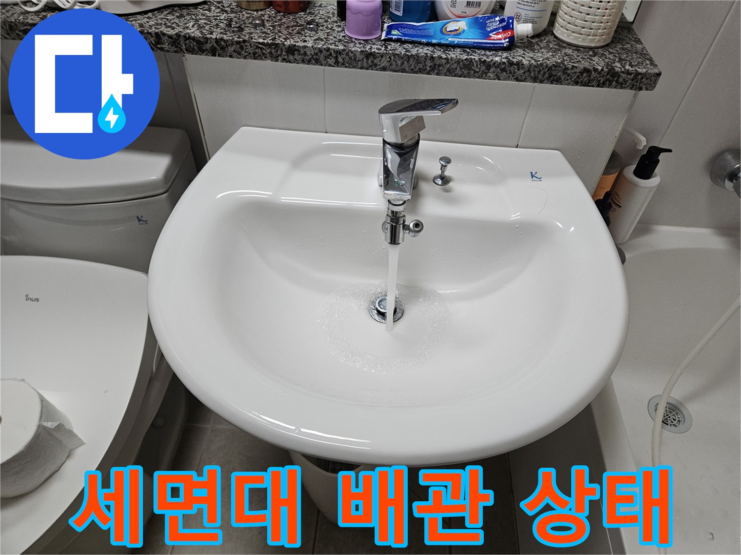 세면대 하부 수전과 연결된 배관의 외관을 촬영한 사진입니다.