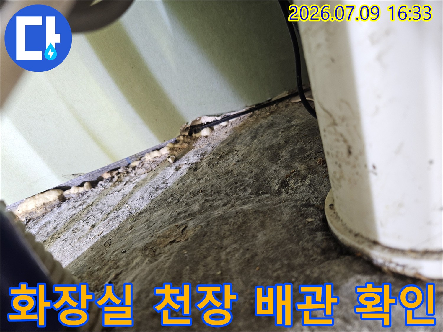 화장실 천장 내부 노출된 배관과 젖은 마감재 상태