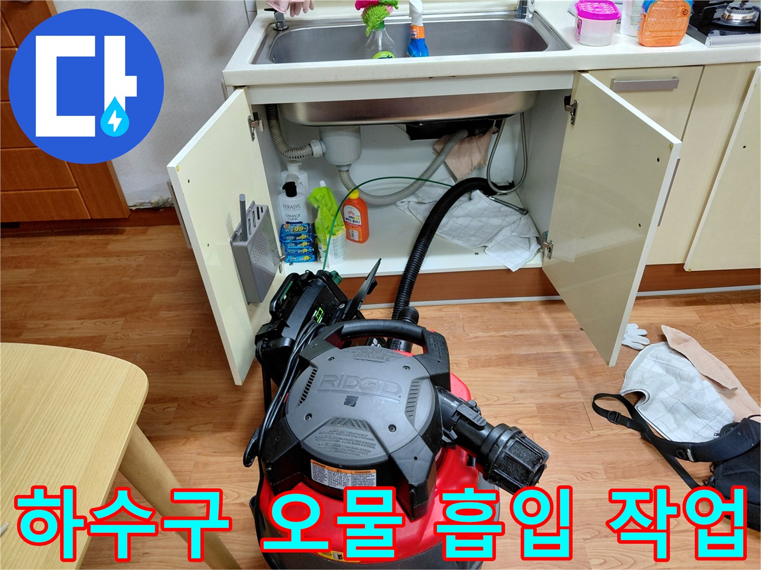 싱크대 하부 배관의 찌꺼기를 빨아들이는 석션기 작업 장면