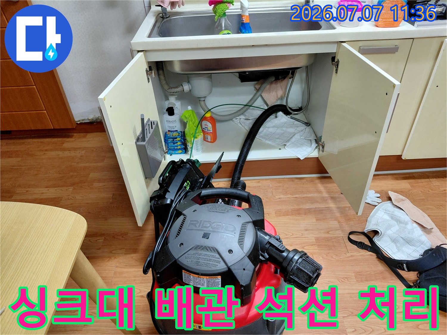전문가용 석션기를 사용하여 싱크대 하부 배관 내 이물질을 제거하는 모습