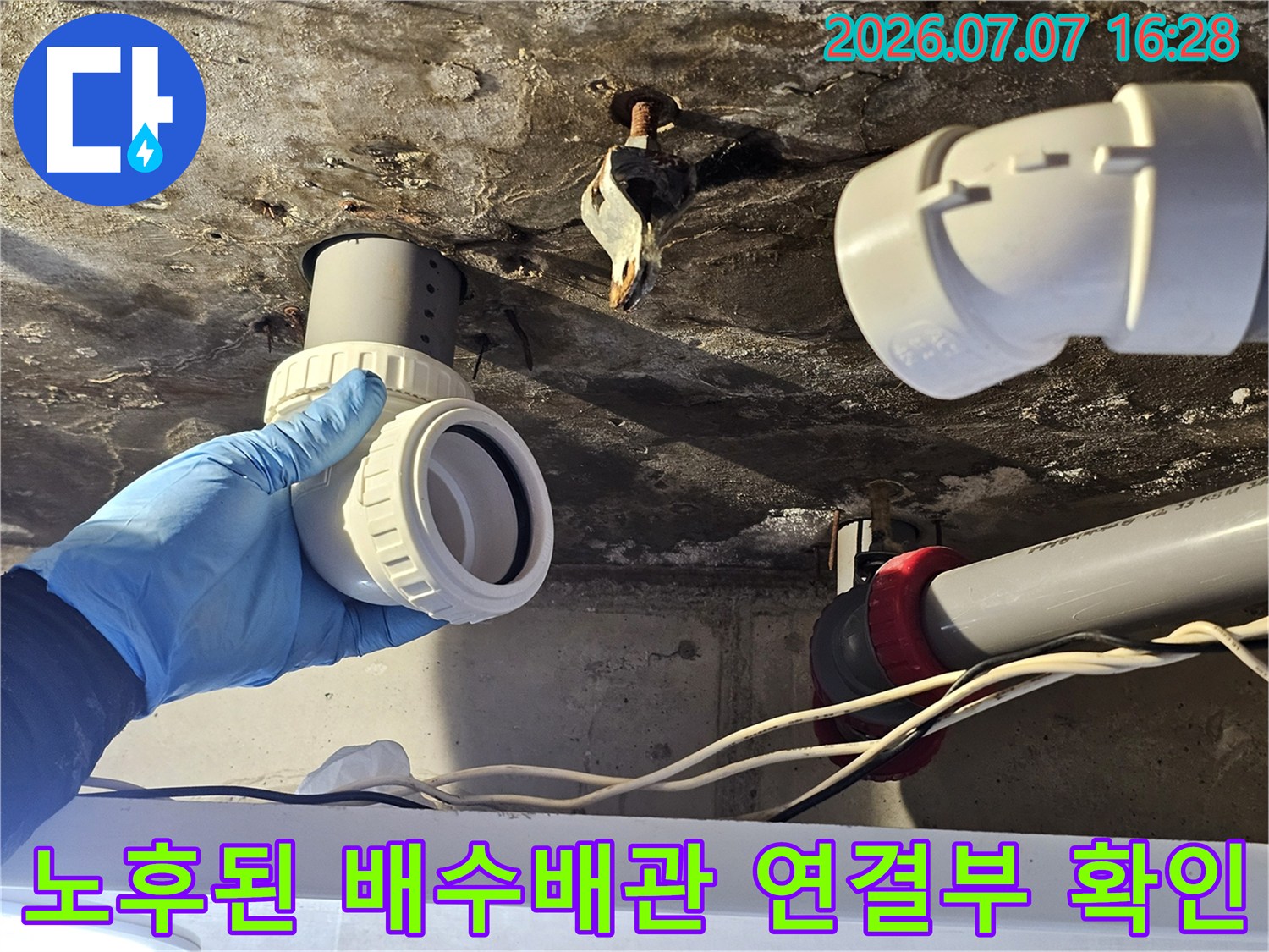 손으로 잡은 노후된 플라스틱 배수관과 연결 부위의 오염 상태
