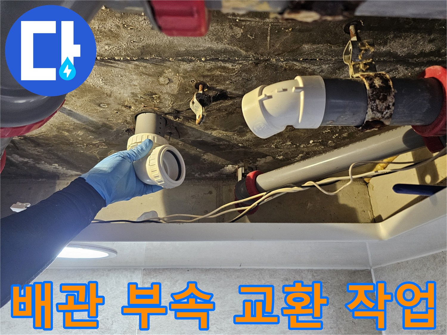 손으로 직접 배관 연결 부품을 끼워 넣어 누수를 막는 장면입니다.