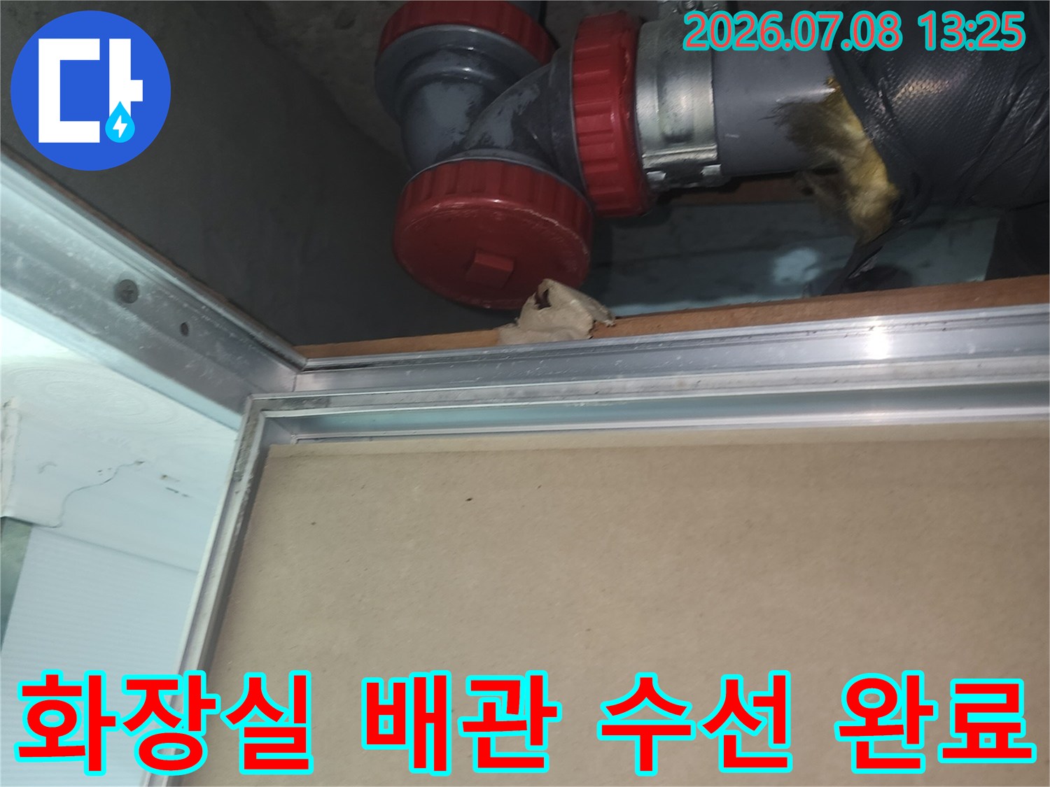 붉은색 캡으로 마감된 화장실 하수관 연결 부위 수리 모습
