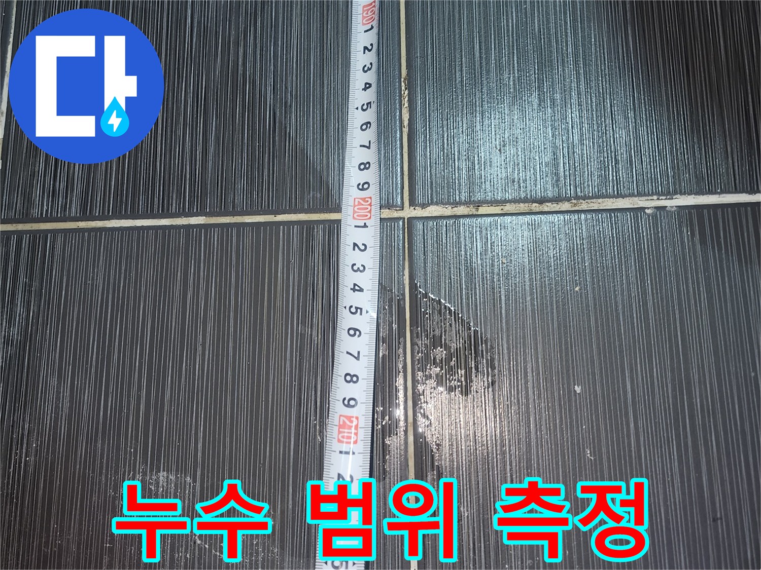 줄자를 사용하여 측정 중인 화장실 천장 타일 구간