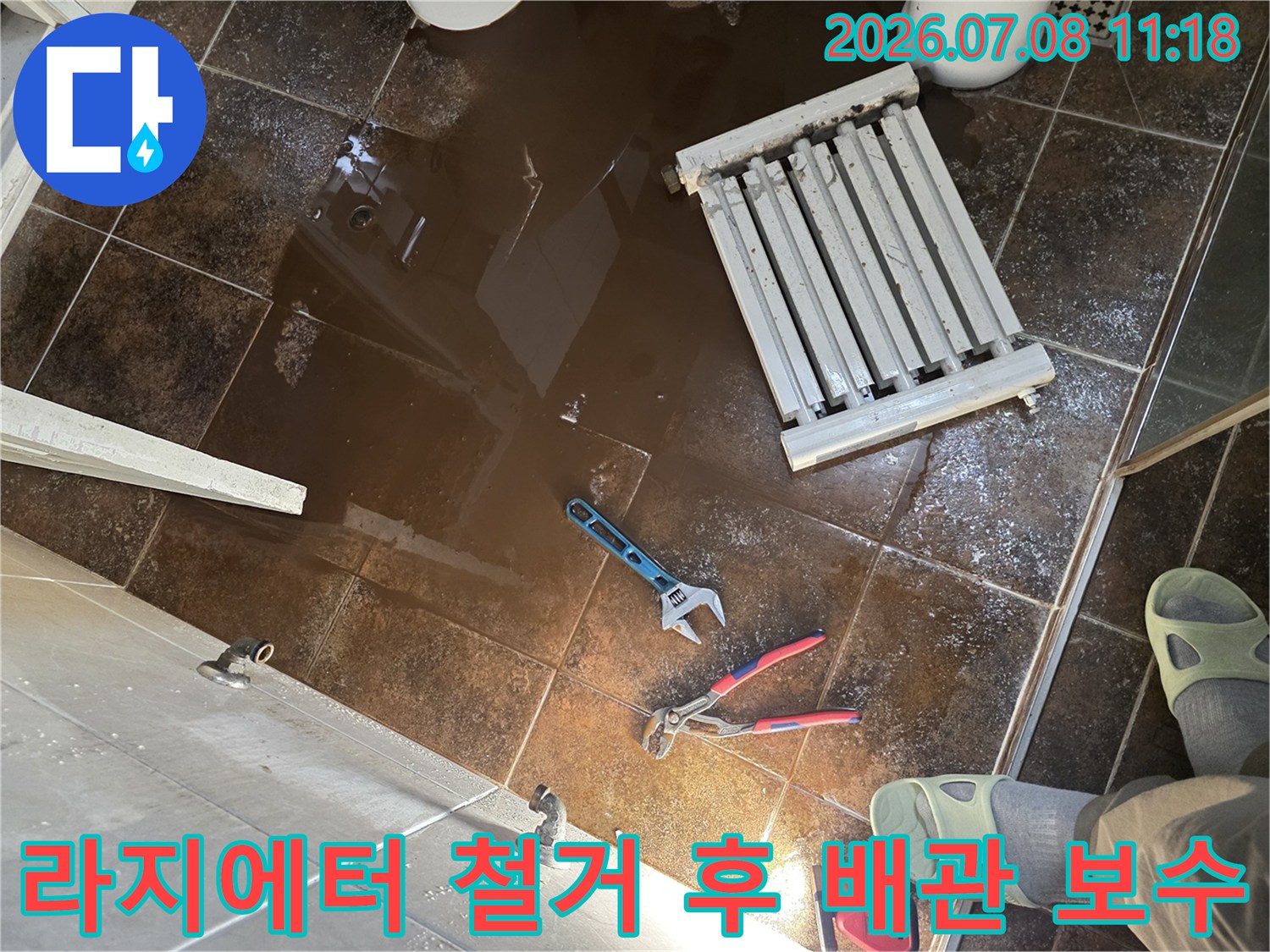 누수가 발생한 화장실 바닥에서 라지에터와 공구를 배치하고 작업 준비하는 모습