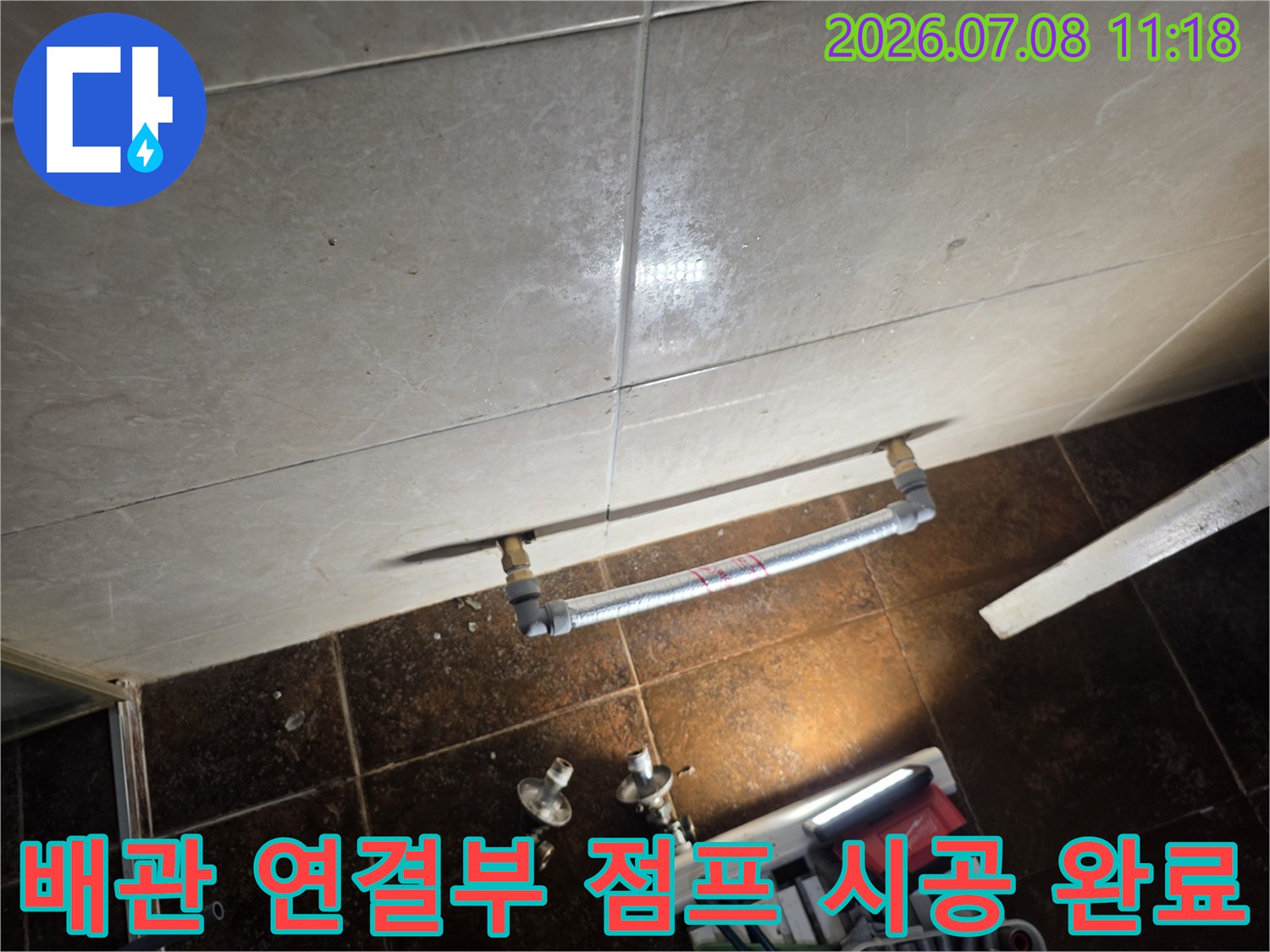 벽면에 고정된 은색 배관과 직관으로 이어진 연결 부위