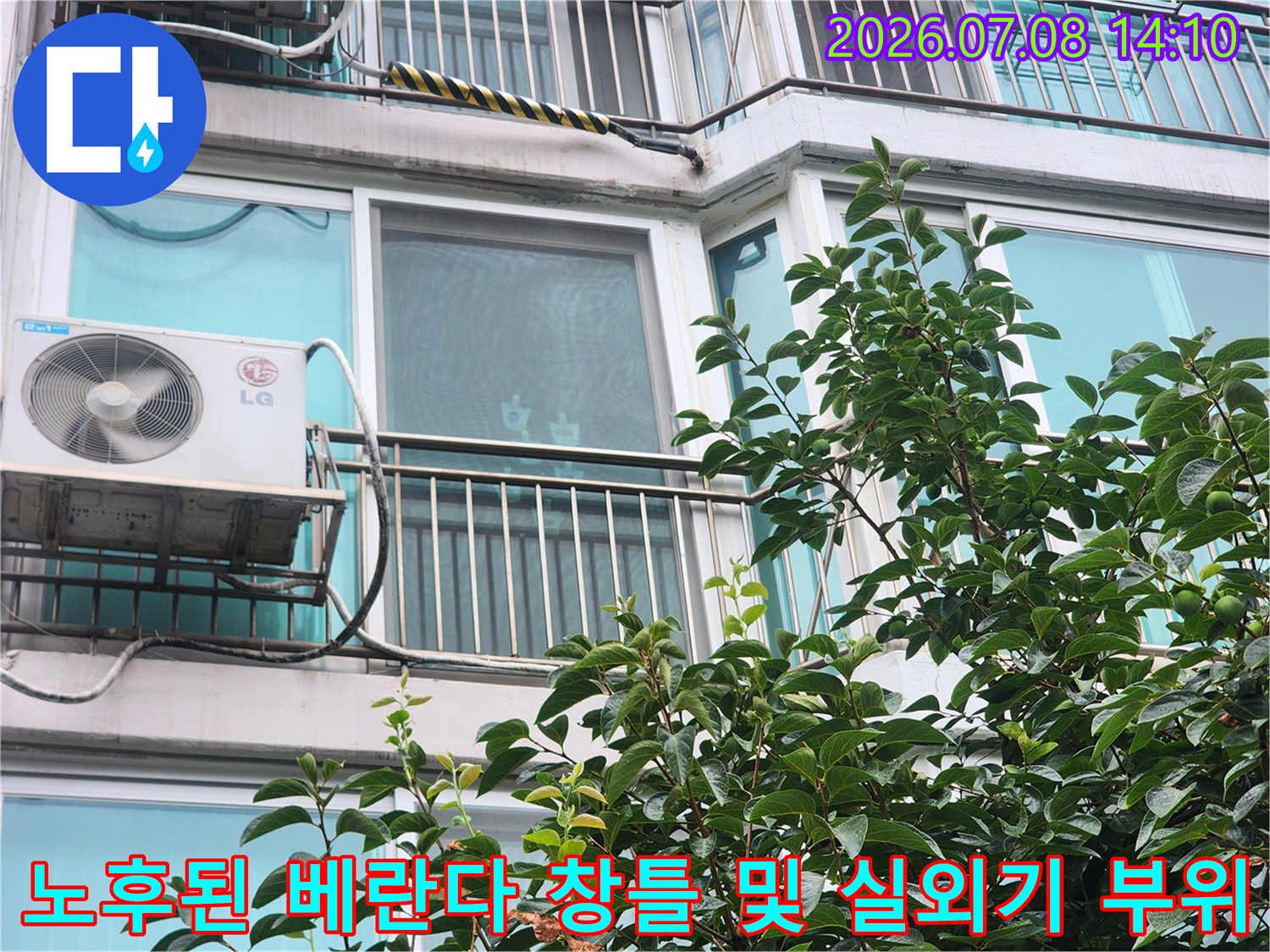베란다에 설치된 에어컨 실외기와 인접한 창문 틀의 상태를 점검하는 장면