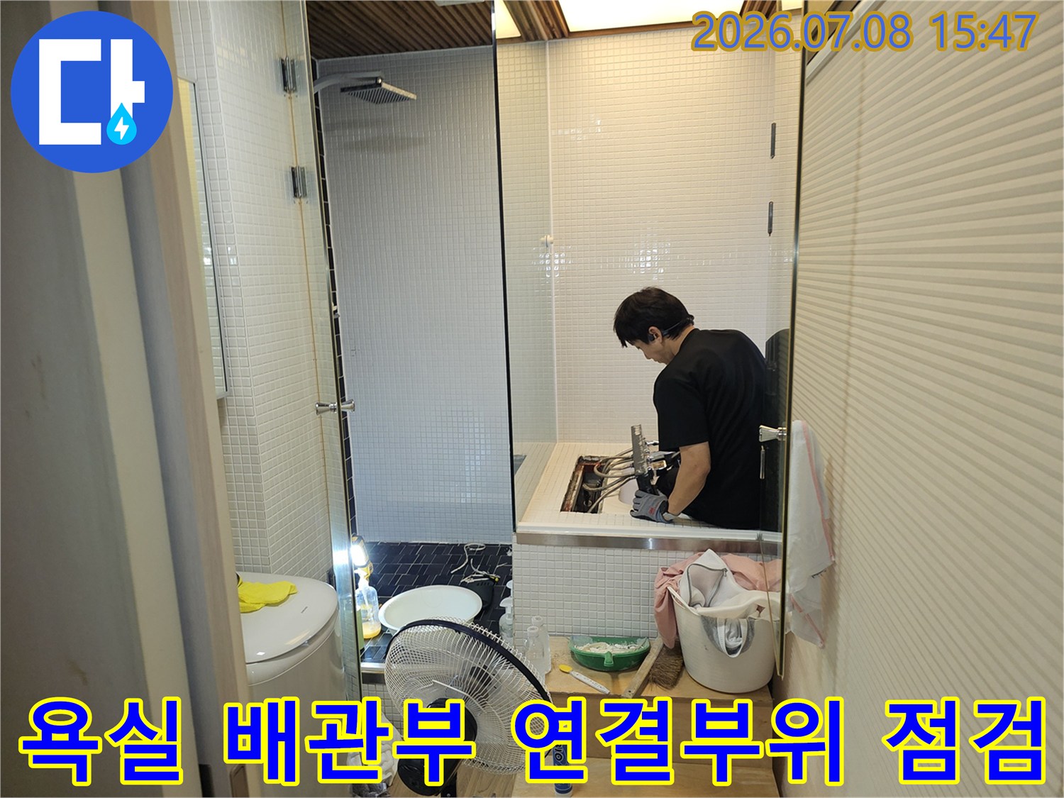 세면대 아래 공간에서 작업자가 배관을 확인하며 누수 여부를 판단하는 모습