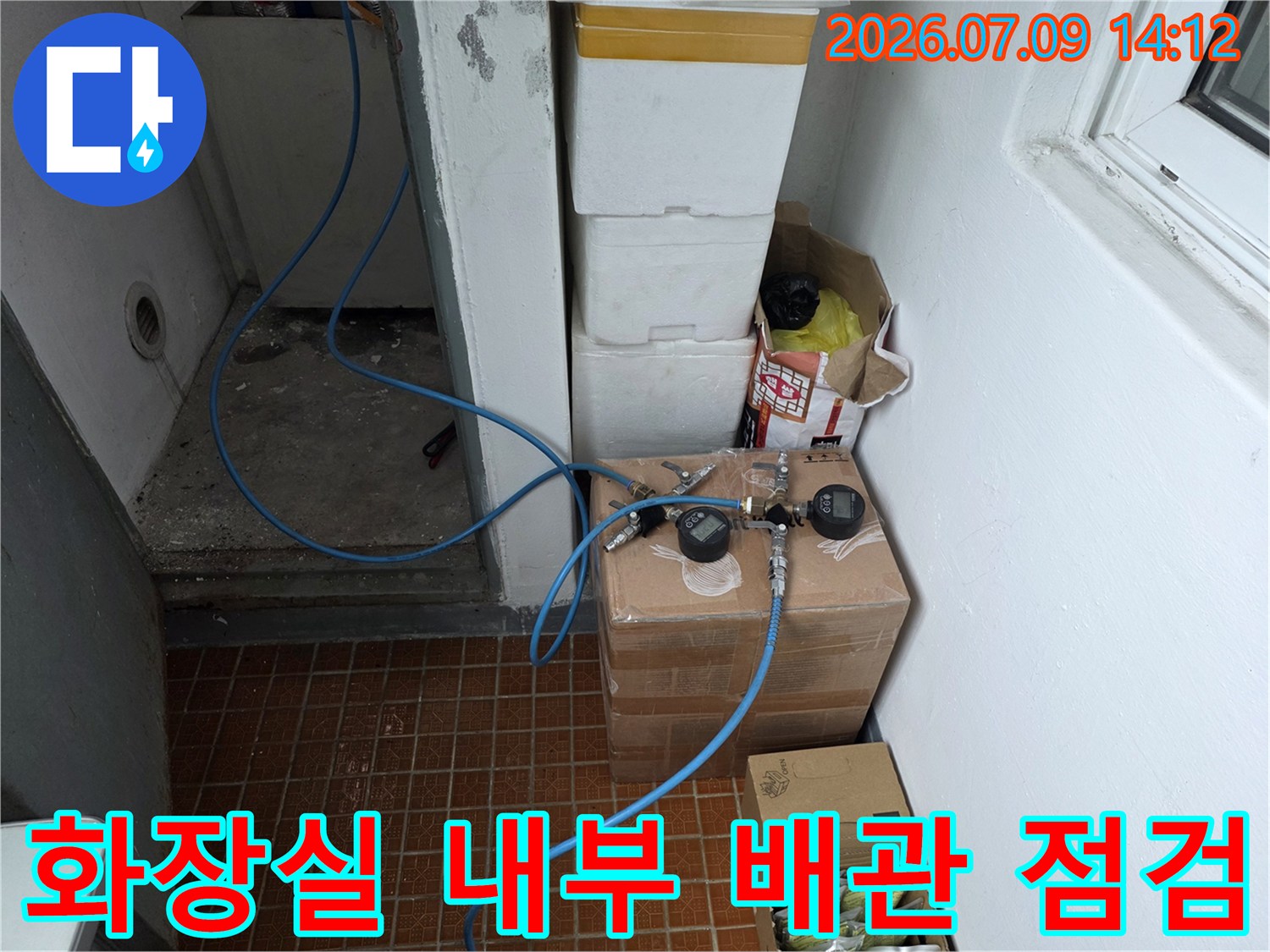 파란색 호스가 연결된 화장실 내 배관 시스템 및 공압 검사 장비