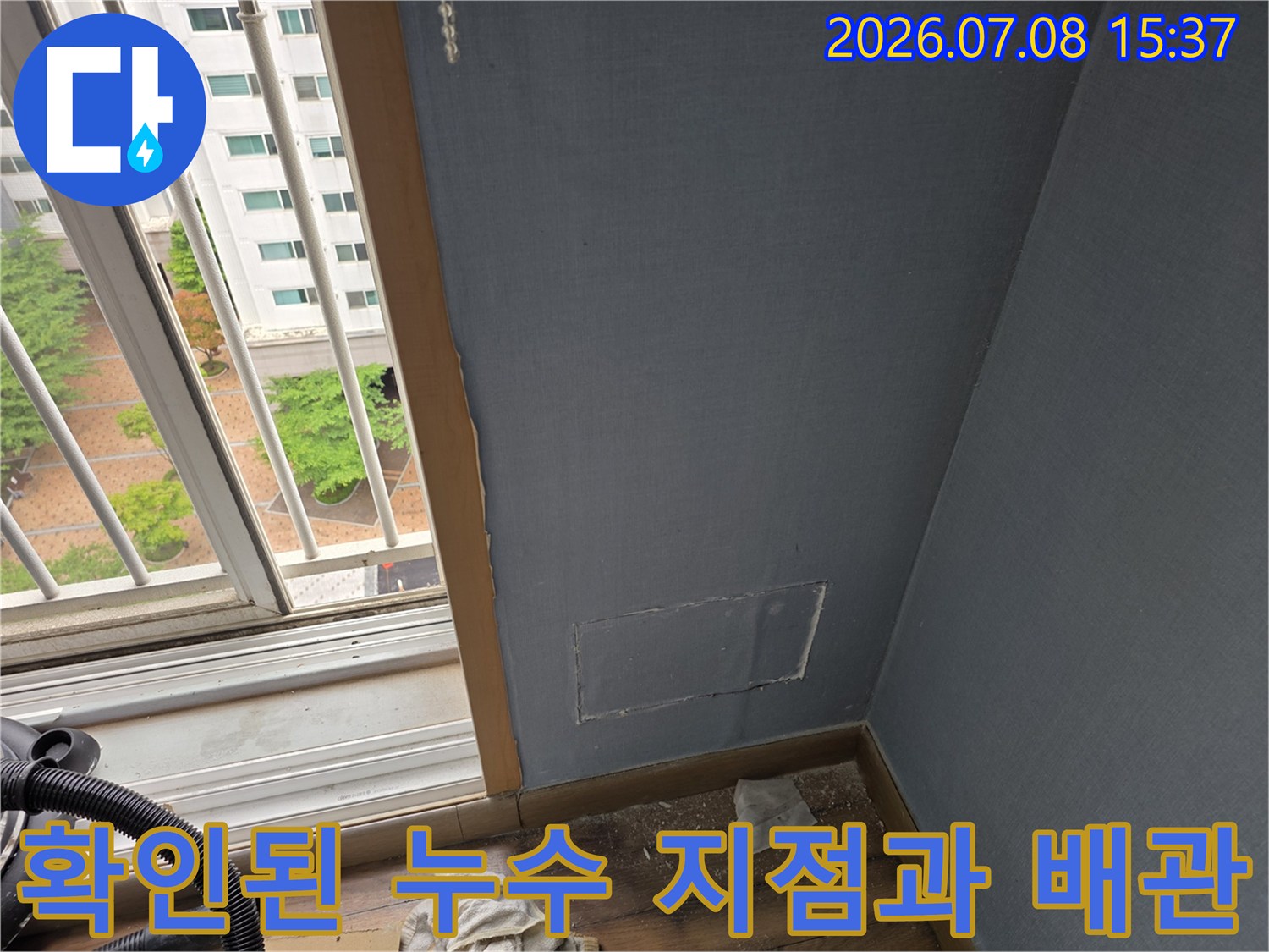베란다 창가 벽면을 절개하여 노출시킨 에어컨 드레인 호스 점검용 사진