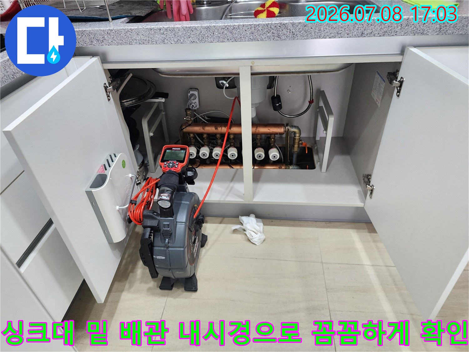 싱크대 아래 설치된 배관들 중 누수가 발생한 지점을 찾기 위해 내시경 카메라를 사용하는 모습