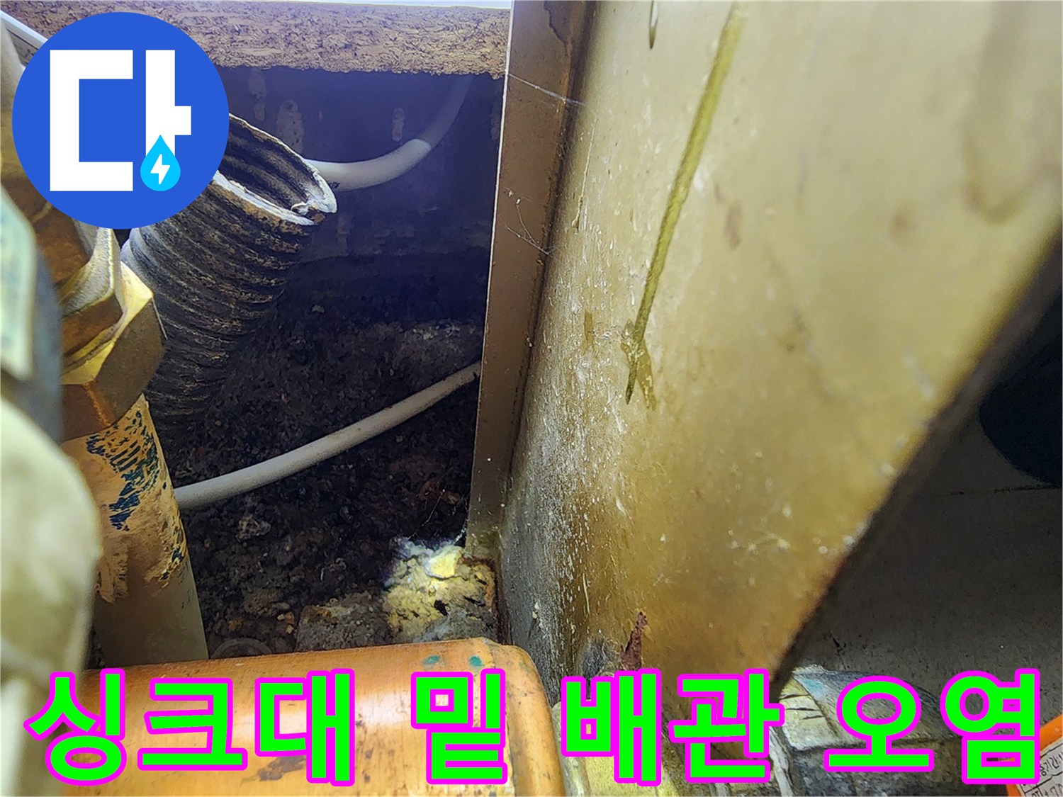 하부장 내부 배관-물에 젖어 어둡게 변한 바닥면과 배관 주변