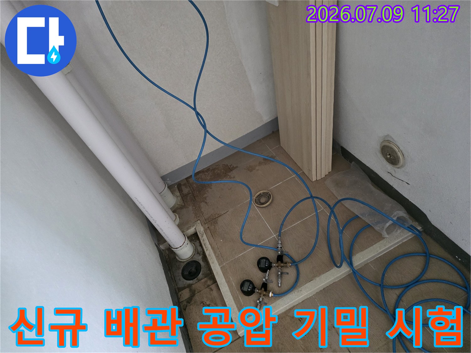 분배기 및 관련 부품에 연결된 파란색 호스와 공압 측정 장비