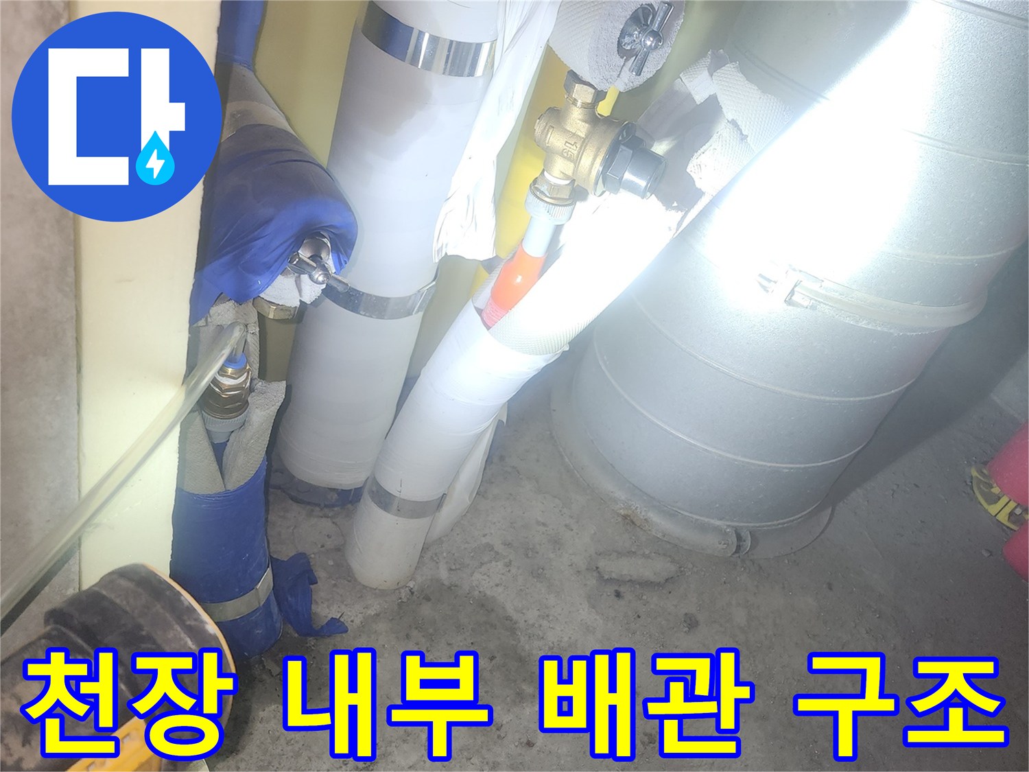 금속 밸브와 은색 보급재로 감싸진 배관의 연결 구간
