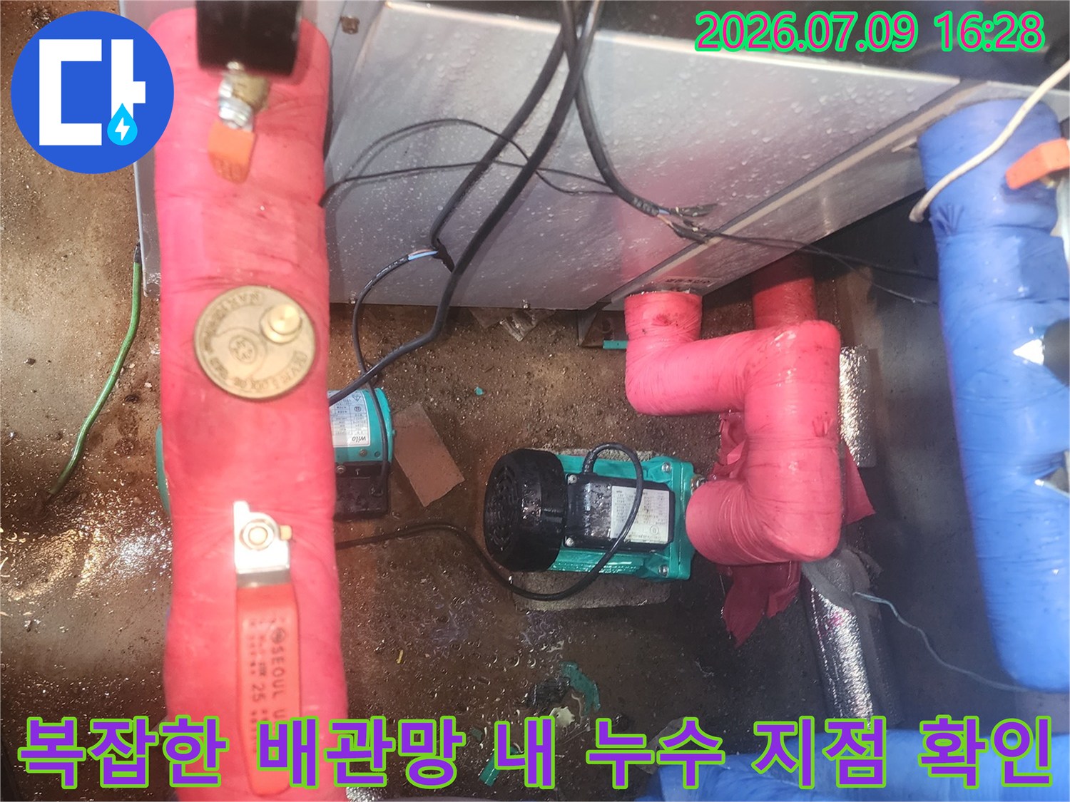 배관 연결 부위에 붉은색 보호재가 씌워진 구간의 누수 점검 모습