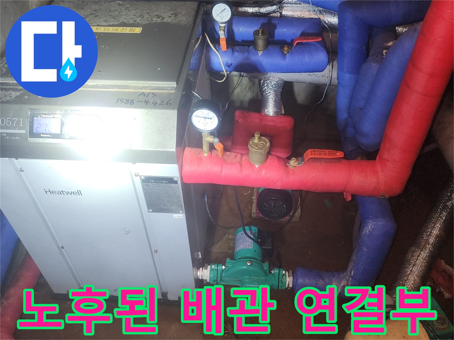 보일러실의 붉은색 배관과 초록색 펌프 장치 상세 사진