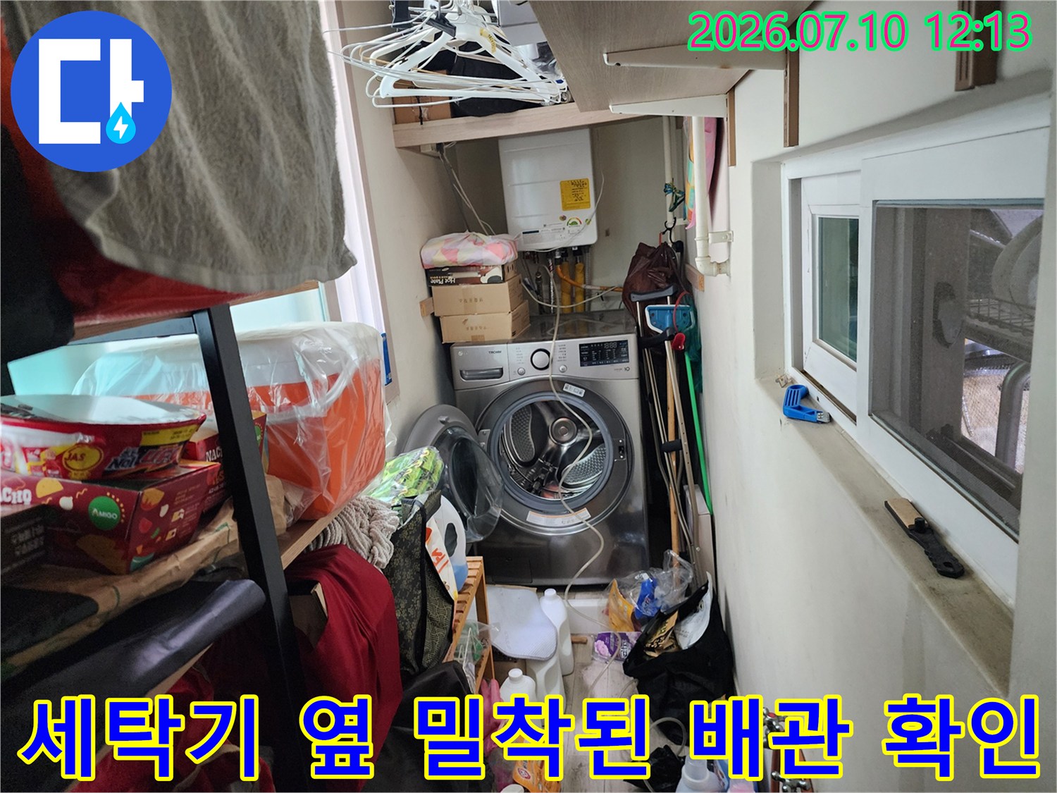다양한 생활용품이 있는 좁은 세탁 공간의 노출 배관 점검 사진