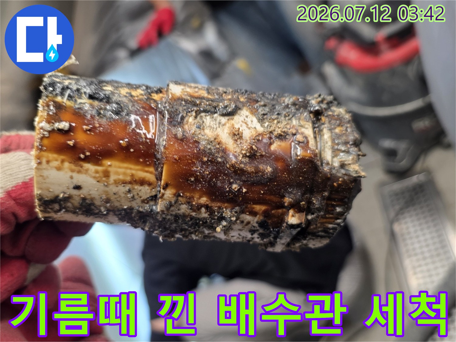 노란 기름 슬러지가 가득 찬 노후된 배수관 내부의 모습