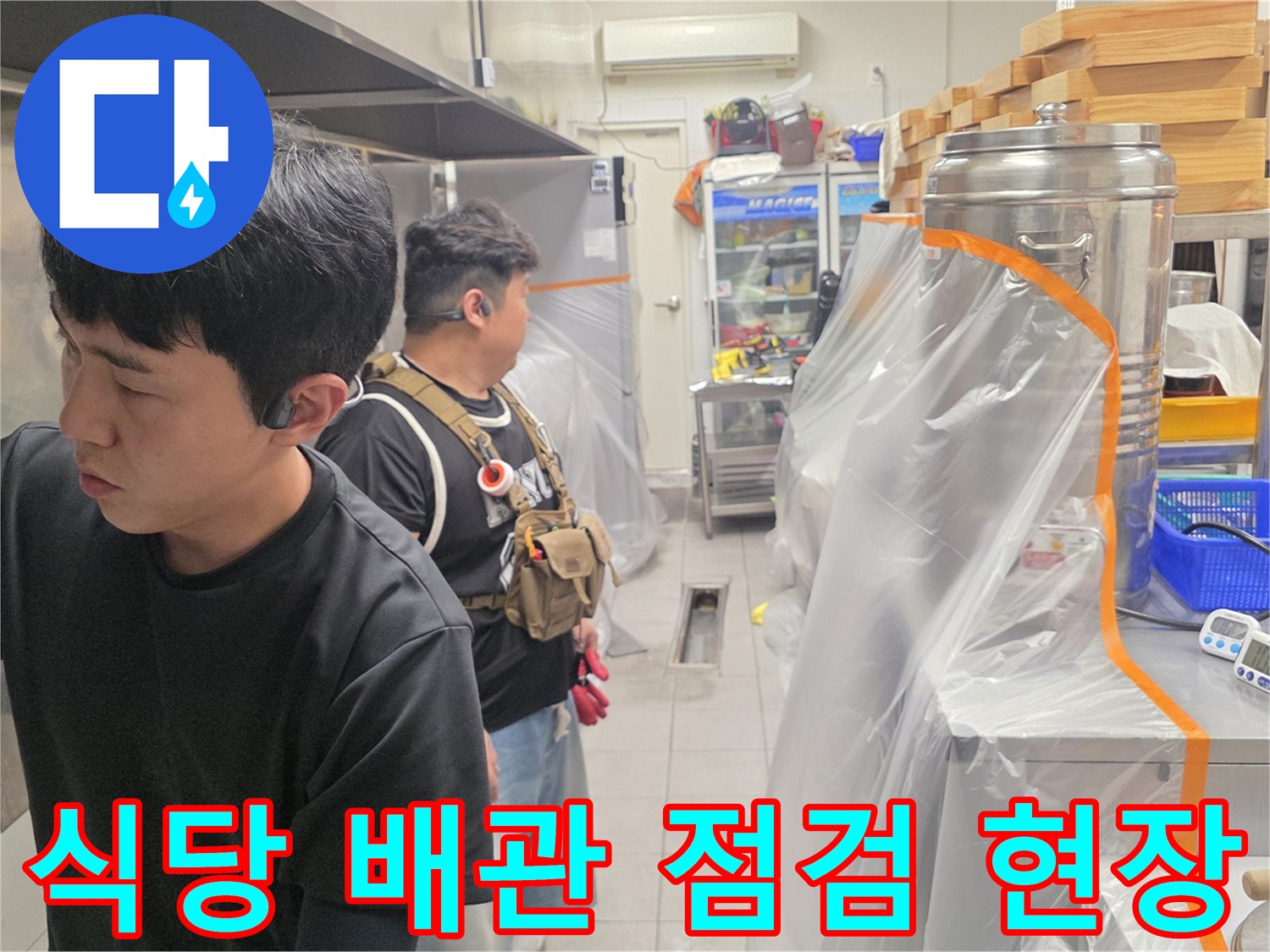 주방 설비와 배관 주변을 면밀히 조사하는 작업자 모습