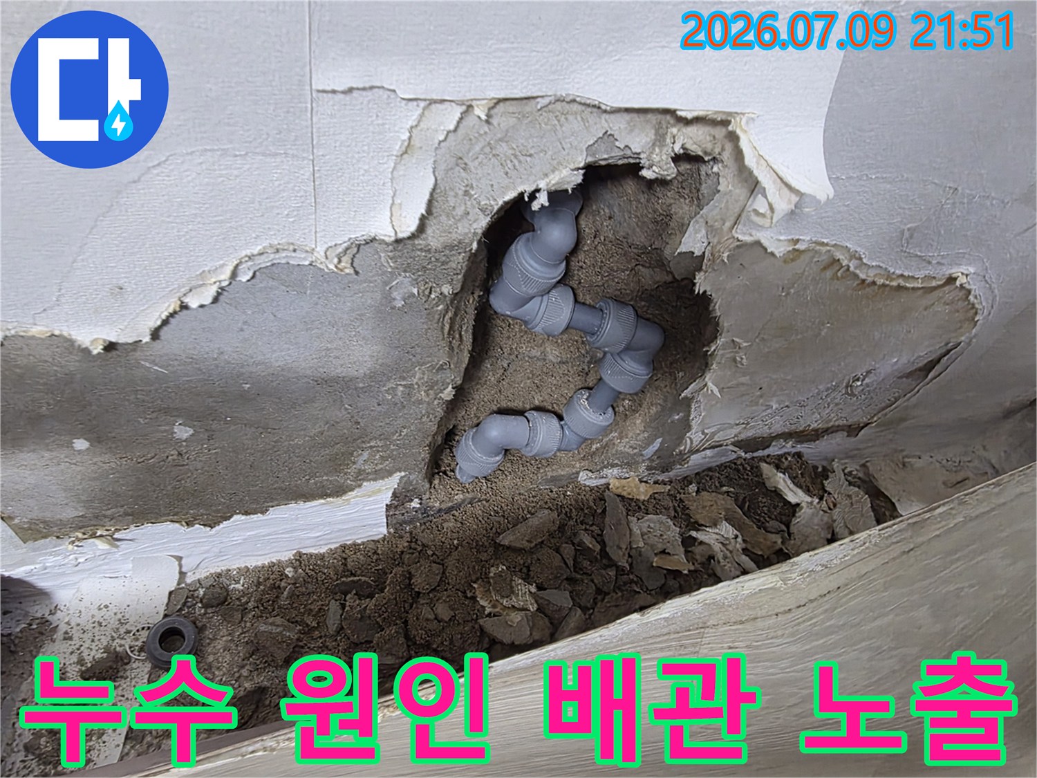 벽면을 뚫고 나온 회색의 배관 연결부와 파손 부위