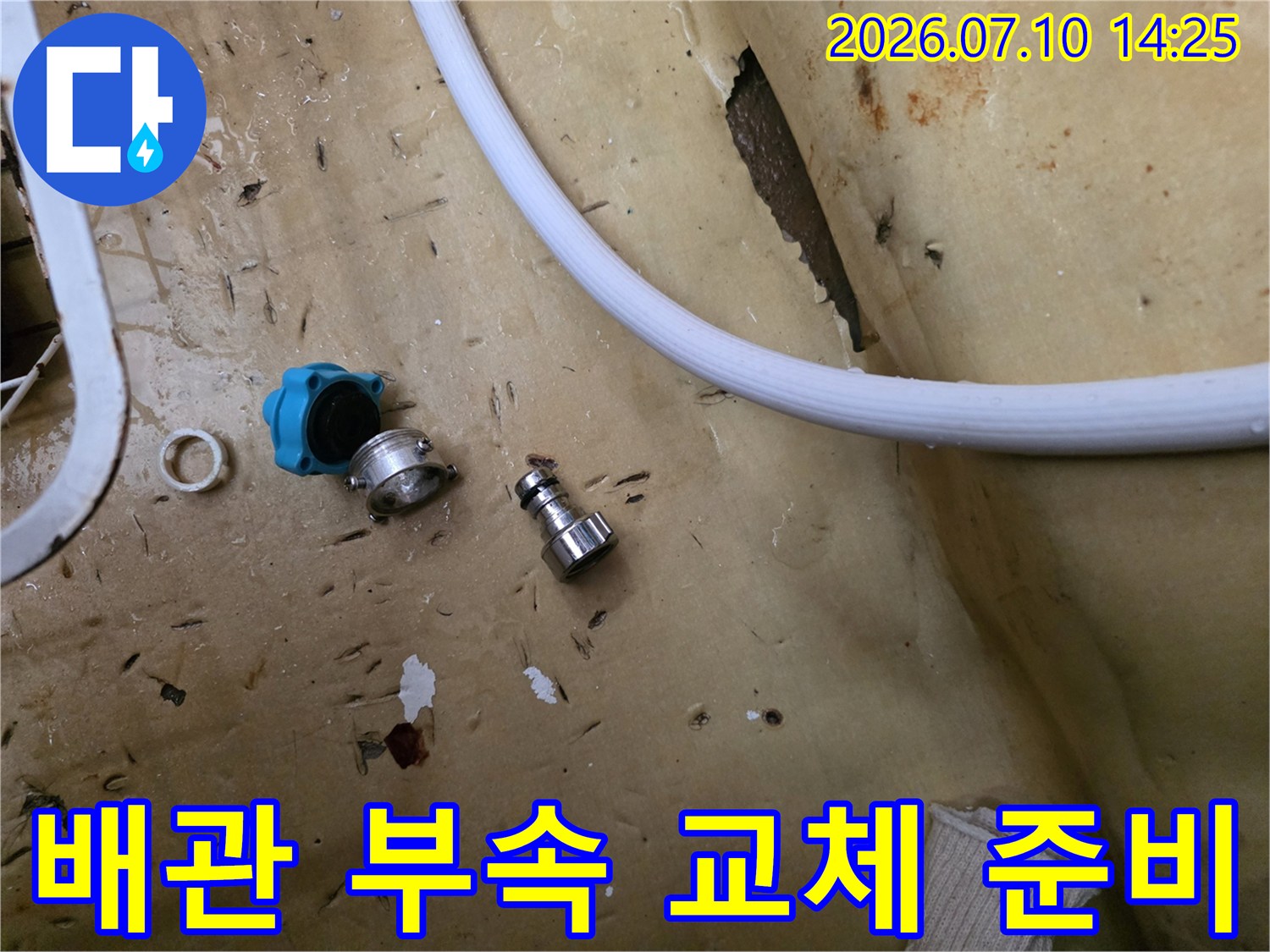노후된 수도 배관 연결 부위의 부실한 부분을 제거하고 새 제품으로 바꿀 준비를 하는 장면