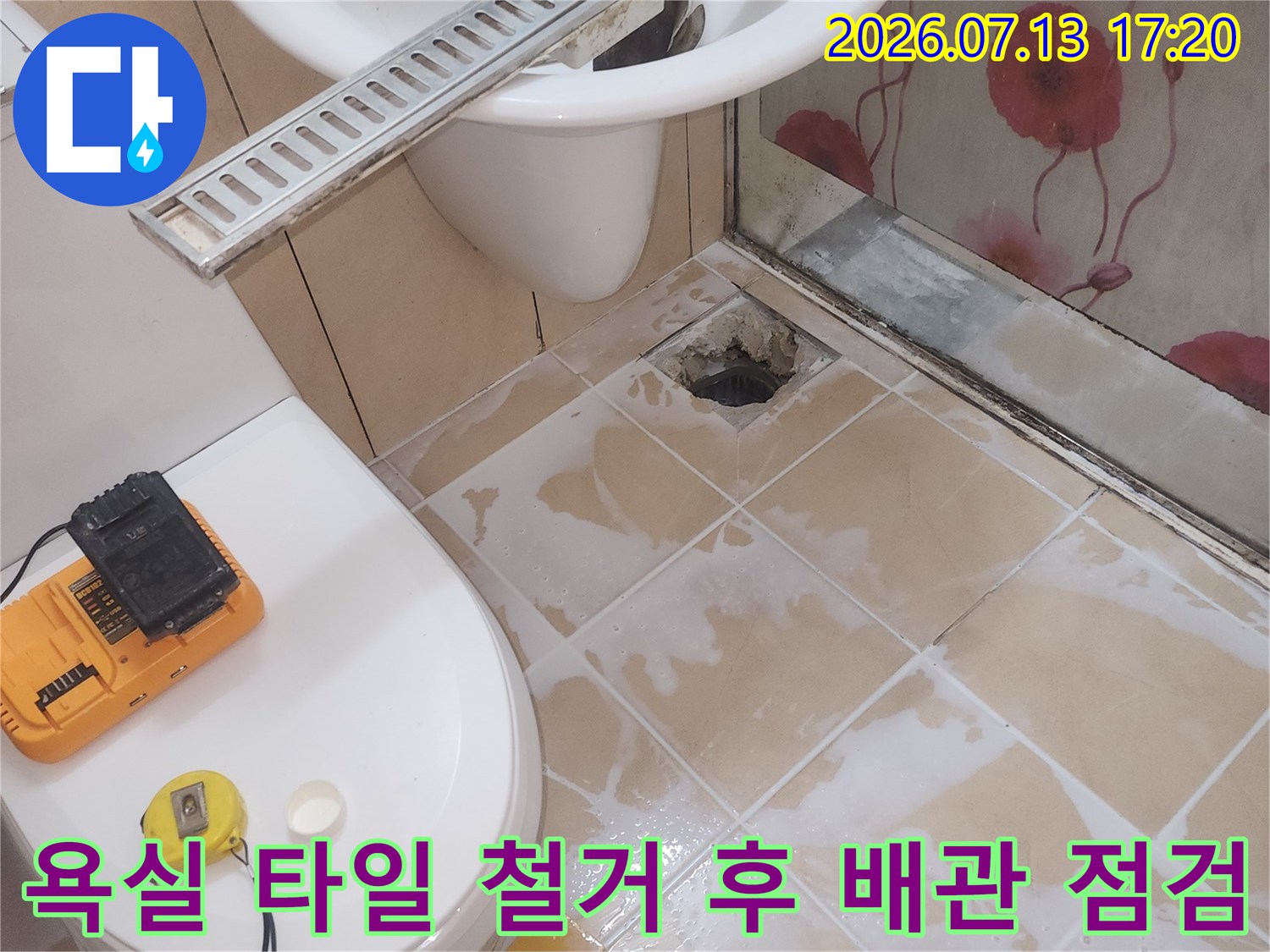 변기 옆 파손된 바닥 면과 노출된 배관 그리고 작업용 소형 공구들