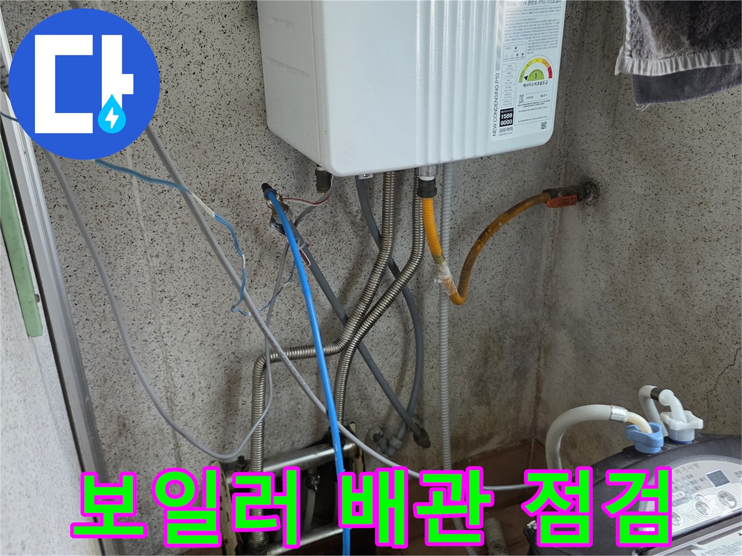 보일러 하단에 연결된 각종 배관과 압력 테스트를 위한 호스 상태