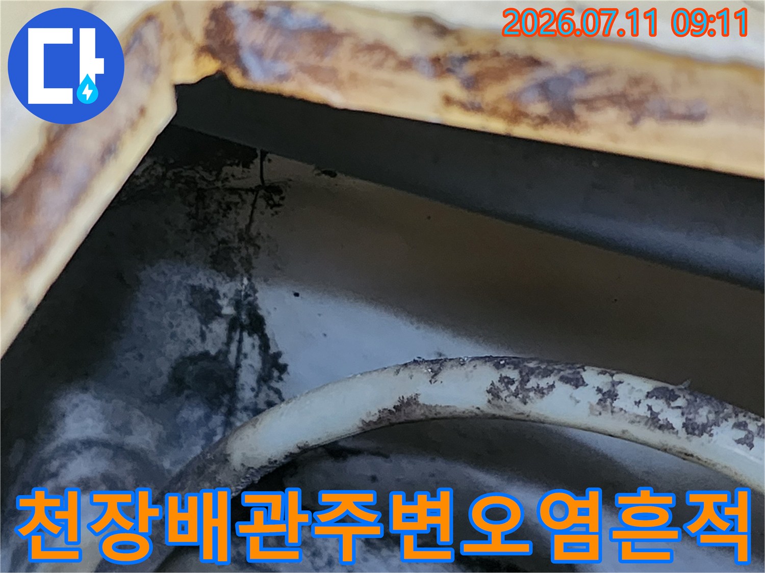 배관 주변의 누수로 인해 변색된 천장 마감재와 콘크리트 표면