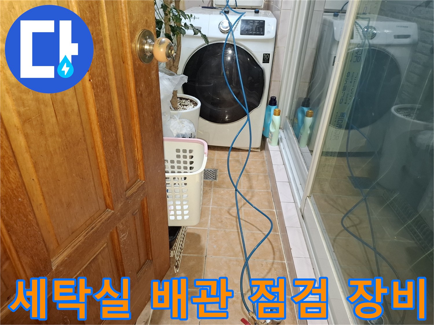 세탁기 옆에 놓인 가스 탐지용 압력 게이지와 파란색 호스