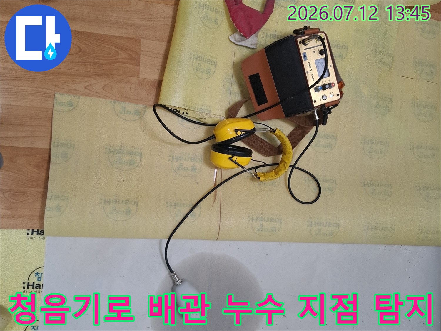 전문 장비인 청음기를 사용하여 바닥 아래 직수 배관의 누수 위치를 정밀하게 파악하는 모습