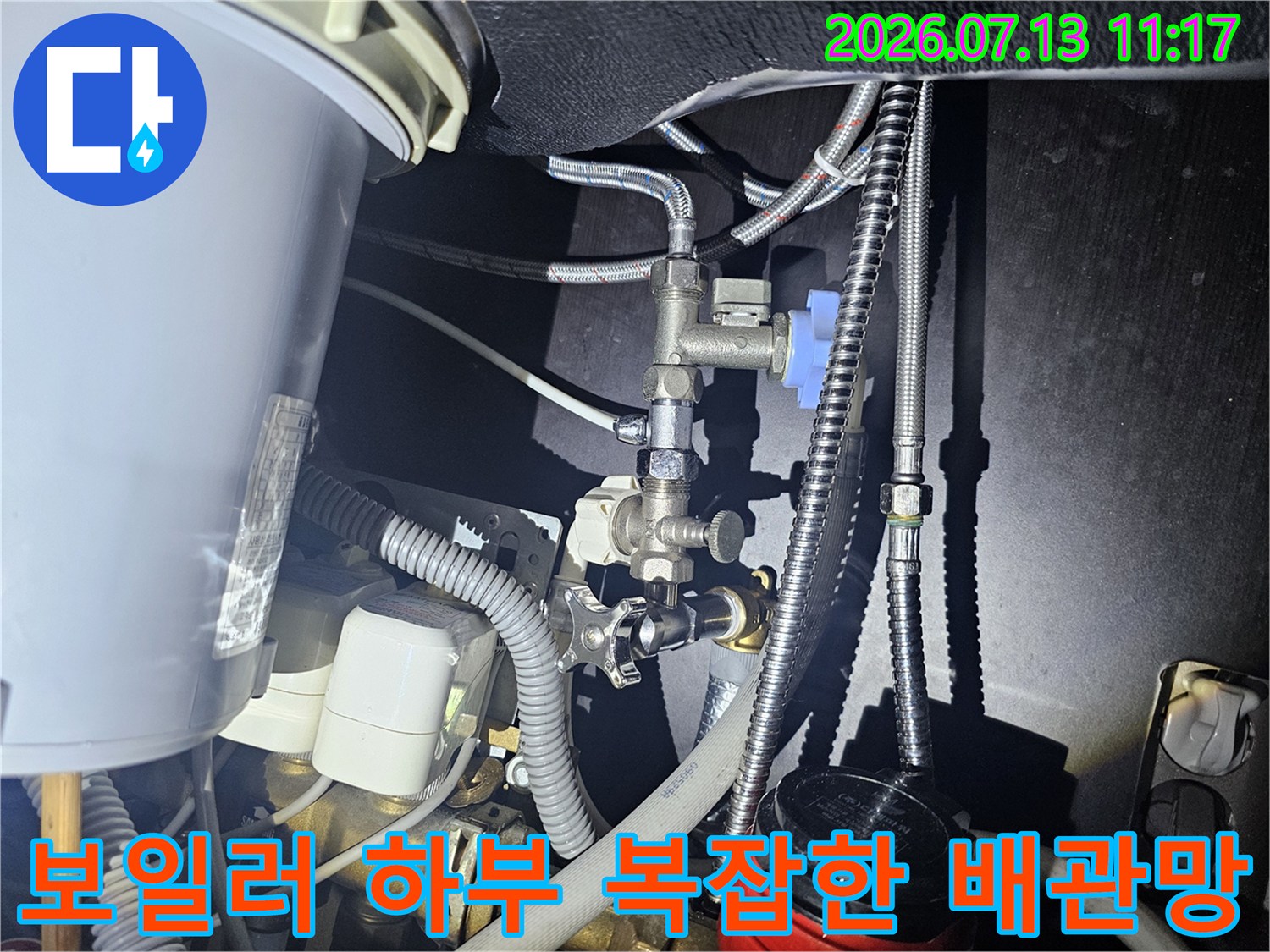 다양한 굵기의 금속 배관과 파란색 제어 밸브가 설치된 모습-상세