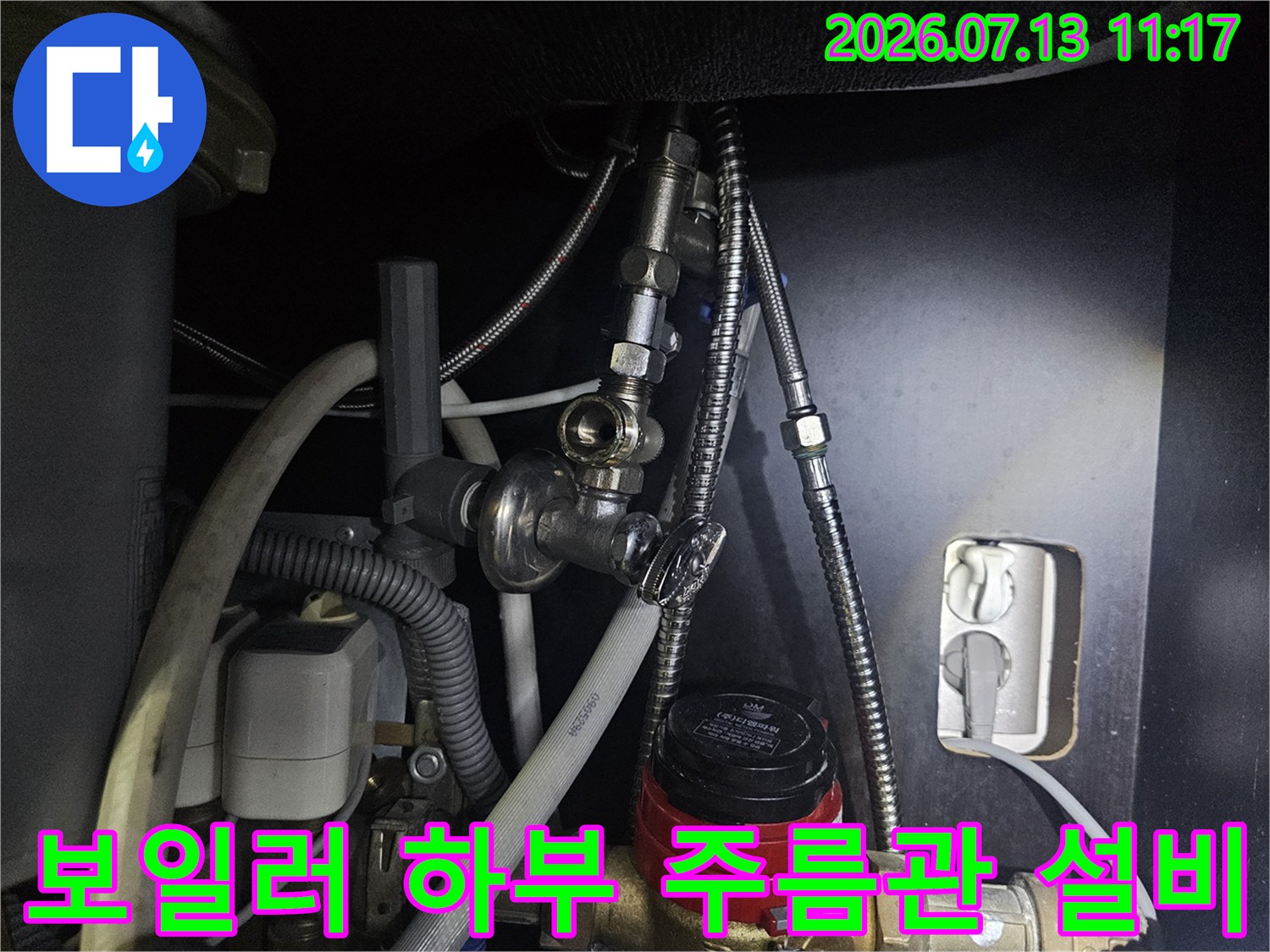 은색 금속 주름관과 빨간색 조작 밸브가 연결된 보일러 아래쪽-사진